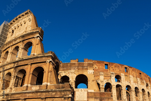 The sun sets on the Colosseum in Rome, Italy, the largest ancient amphitheatre ever built, during a cloudless summer day.