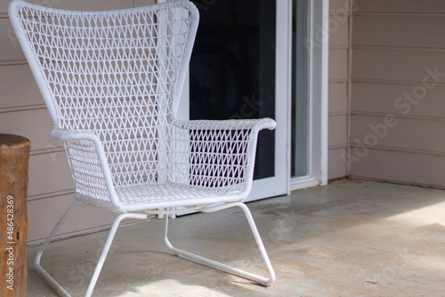 white outdoor chairs on patio of country side cottage