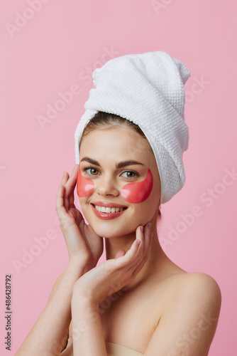 beautiful woman skin care face patches bare shoulders pink background