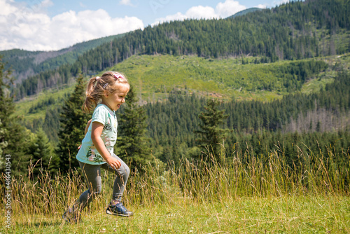 Obraz na płótnie Little girl is relaxing on meadow . Tatra mountains in background. Summer vacation w salonie