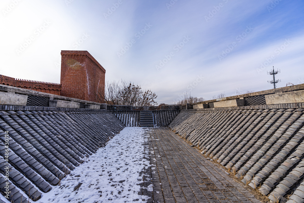 Red brick building with snow covered roof in winter Red brick building with snow covered roof in winter
