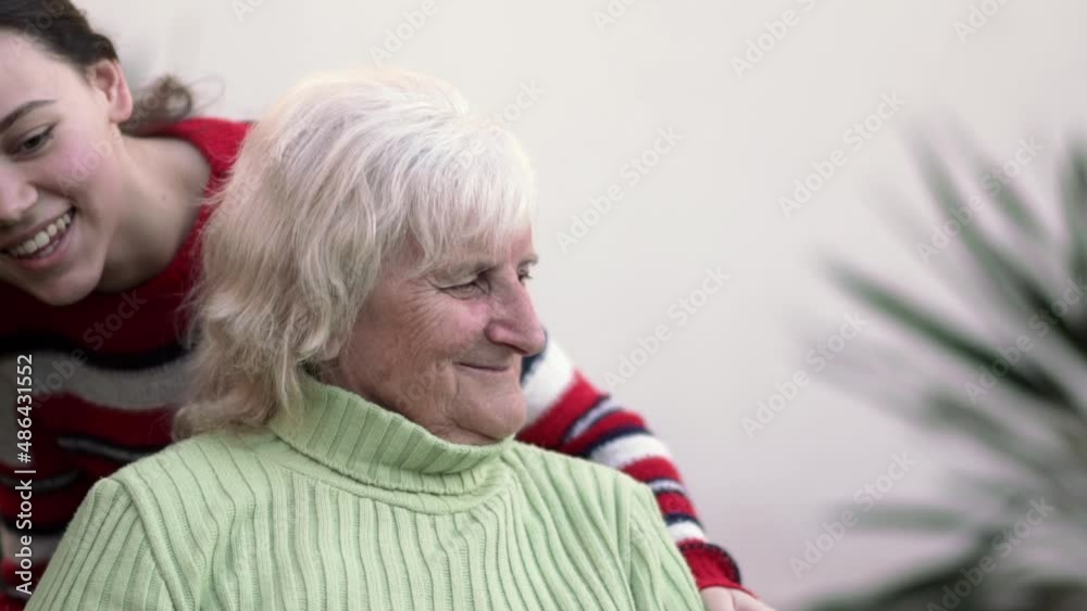 Portrait of smiling mature woman embracing cute little girl tenderly, slow motion Portrait of smiling mature woman embracing cute little girl tenderly, slow motion