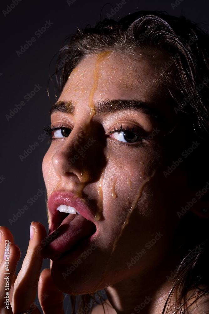Foto de Sensual young woman face with honey drop close up. Sexy model with  honey drip on face. Honey mask. do Stock | Adobe Stock