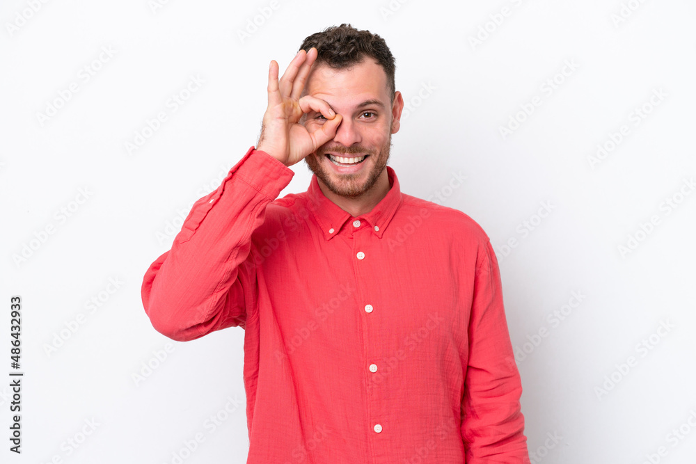 Young Brazilian man isolated on white background showing ok sign with fingers Young Brazilian man isolated on white background showing ok sign with fingers