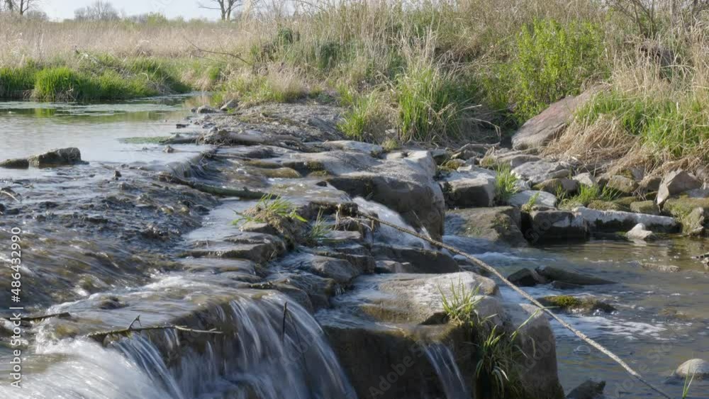 Looking across small water fall on creek, video of Scenery of river with rocks, Forest, flowing river, fallen leaves. Slow drift left shoot Looking across small water fall on creek, video of Scenery of river with rocks, Forest, flowing river, fallen leaves. Slow drift left shoot
