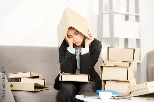 Busy businesswoman with folder on head, secretary girl working alone late in office. Angry sad secretary, upset accountant employee at office.