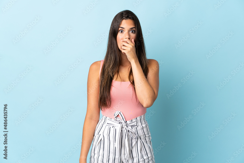 Young brazilian woman isolated on blue background surprised and shocked while looking right Young brazilian woman isolated on blue background surprised and shocked while looking right