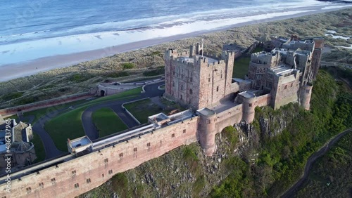 Bamburgh Castle in Northumberland World Heritage Site on Northeast coast of England - Aerial Drone 4K HD Footage Fly Right photo