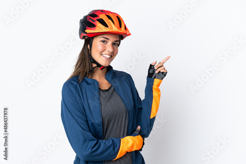 Young cyclist brazilian girl isolated on white background pointing finger to the side