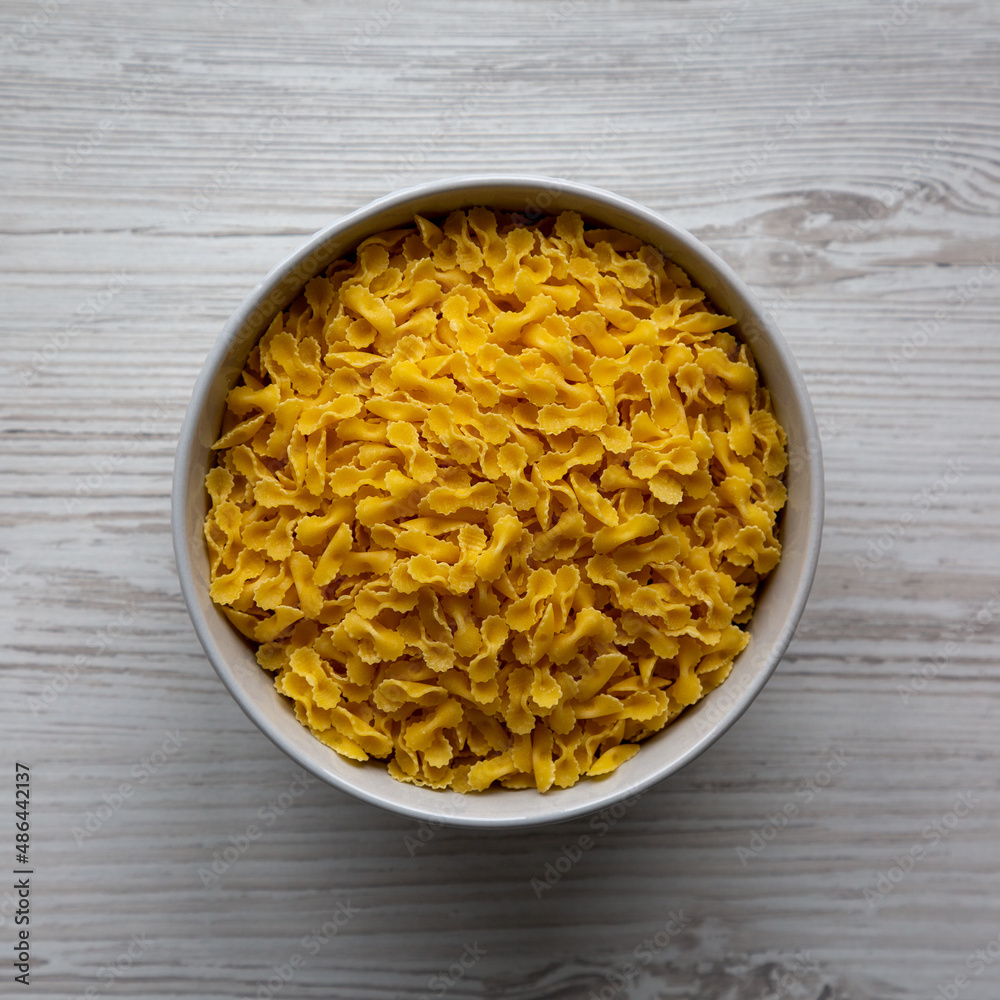 Healthy Dry Farfalline Pasta in a Bowl, top view. Flat lay, overhead, from above. Healthy Dry Farfalline Pasta in a Bowl, top view. Flat lay, overhead, from above.