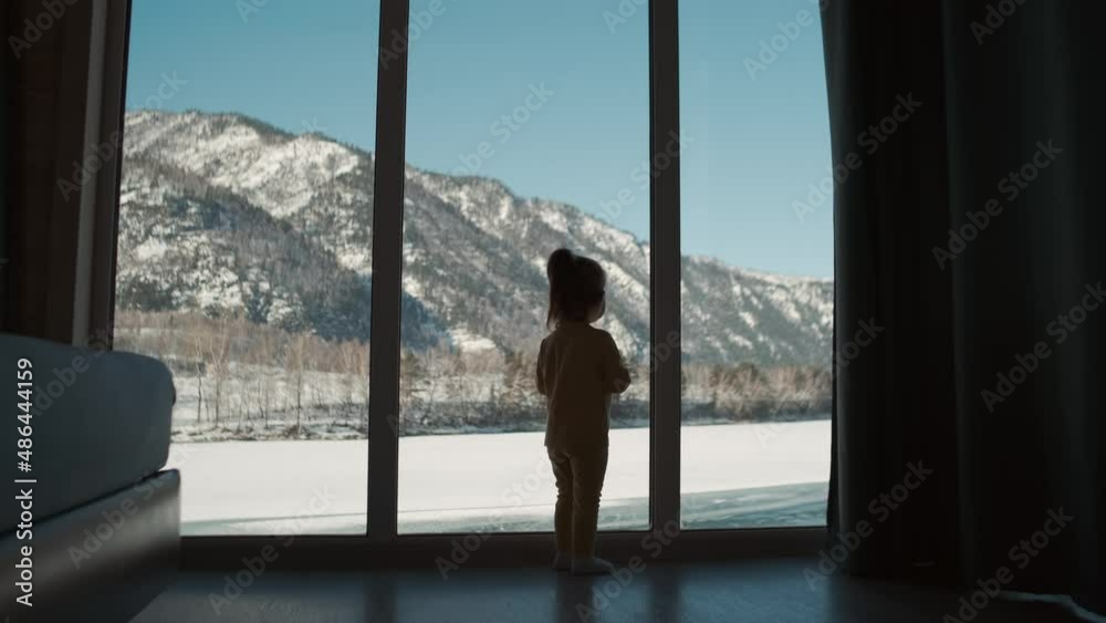 A small child approaches the window at home during self isolation. A small child approaches the window at home during self isolation.