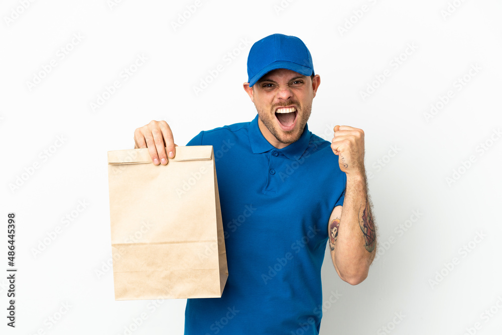 Brazilian taking a bag of takeaway food isolated on white background celebrating a victory in winner position Brazilian taking a bag of takeaway food isolated on white background celebrating a victory in winner position