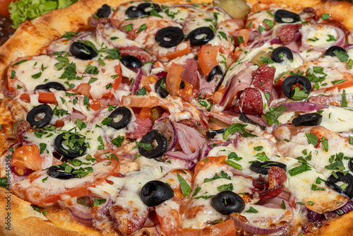 Pizza with bacon and cheese, herbs and cherry tomatoes. With mozzarella, shrimps and octopuses, mussels and other products on a wooden background.