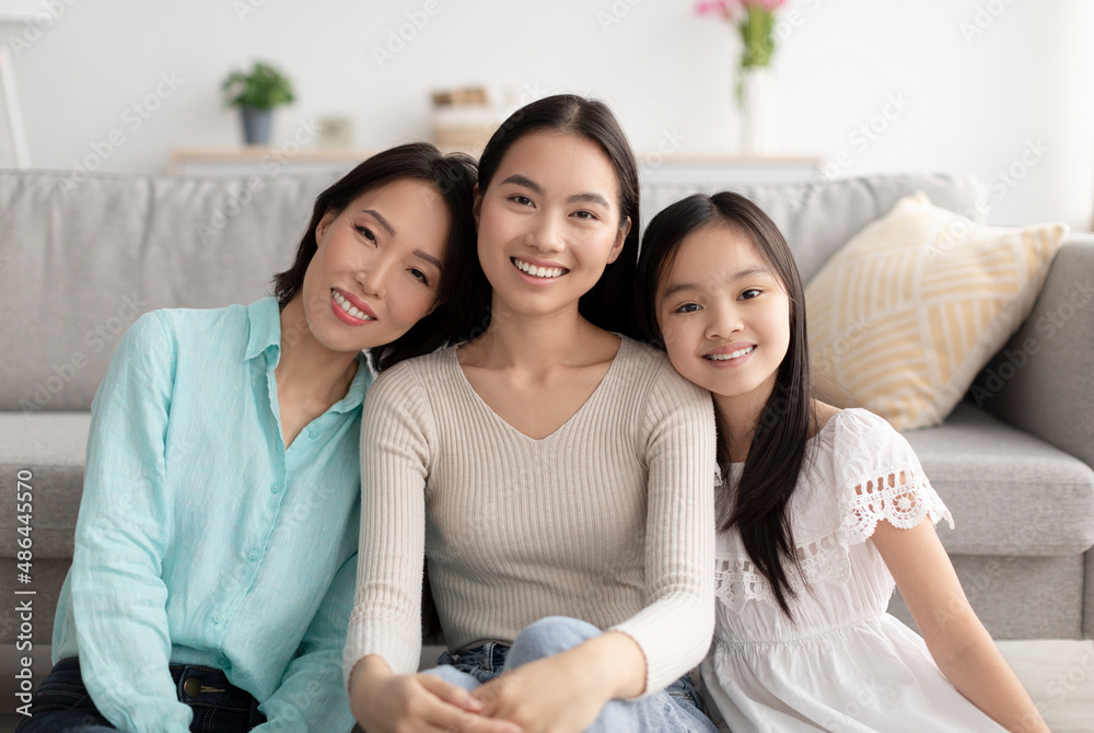 Portrait of happy multi generation Asian family sitting on floor and smiling at camera at home Portrait of happy multi generation Asian family sitting on floor and smiling at camera at home