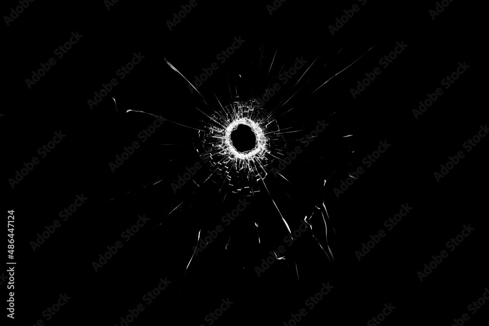 Obraz premium Texture of broken glass. Hole from a ball on a black background.
