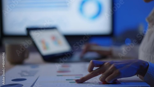 Businesswoman working late at night using laptop and graph for her finance. Young female learning and study for investment at home office
