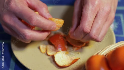 Man peeling a tangerine with hands. Healthy food concept