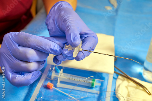 Epidural anesthesia. Tuohy needle in doctor's hands close up photo