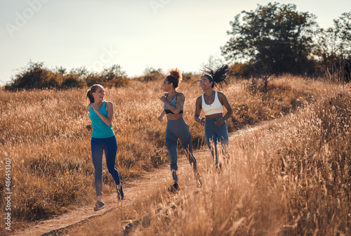 Group of sporty female friends running outdoors.