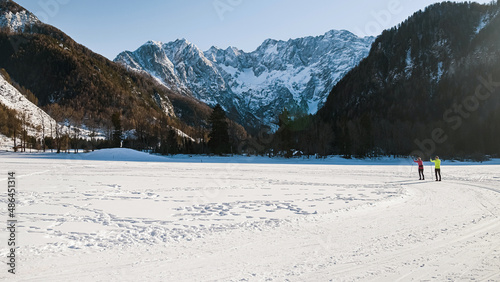 Couple recreational cross country skiing in a forest surrounded by winter nature and snow.