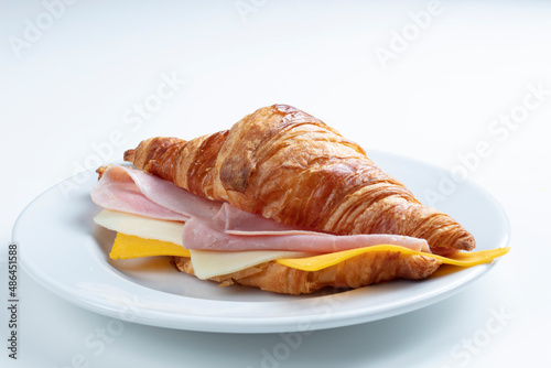 Croissant con jamón y queso sobre fondo blanco. croissant with ham and cheese on white background