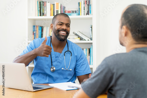 Laughing african american doctor with good news for patient