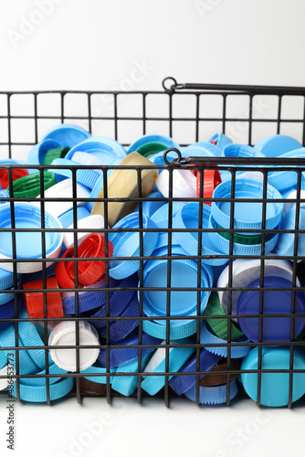 Plastic bottle caps in a metal basket. Recyclable waste