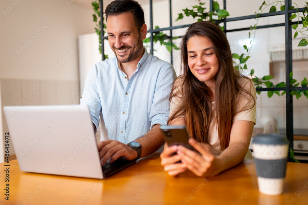 Couple using smart phone and laptop Couple using smart phone and laptop