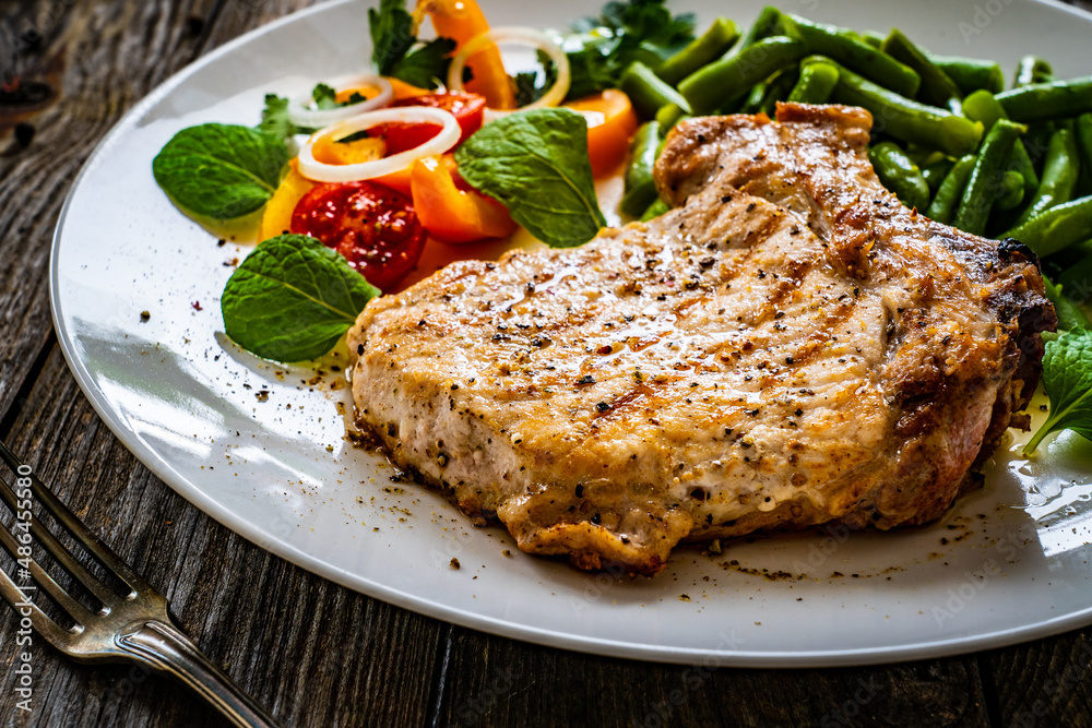 Grilled steak with boiled green bean on wooden table 