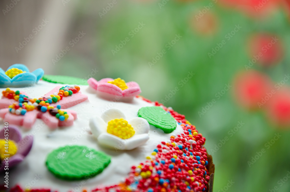 Traditional Easter cake decorated with icing and Easter decor: cross, flowers, leaves, dragee with molasses. Traditional sweets for the Christian holiday. Festive background with copy space. Traditional Easter cake decorated with icing and Easter decor: cross, flowers, leaves, dragee with molasses. Traditional sweets for the Christian holiday. Festive background with copy space.