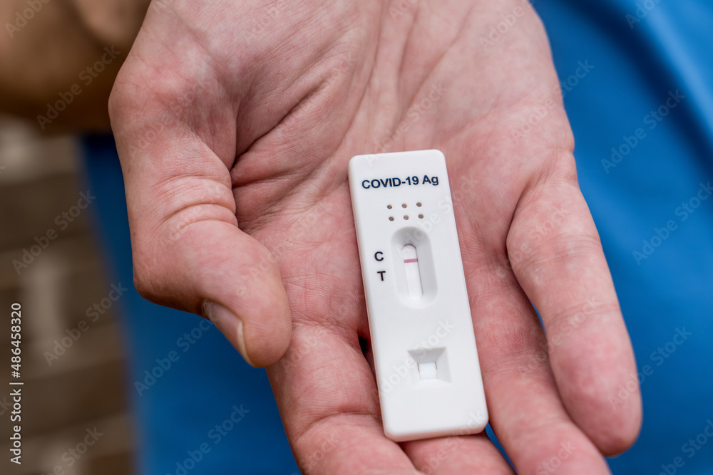 Hand holding Covid-19 rapid antigen test cassette with negative result of rapid diagnostic test Hand holding Covid-19 rapid antigen test cassette with negative result of rapid diagnostic test