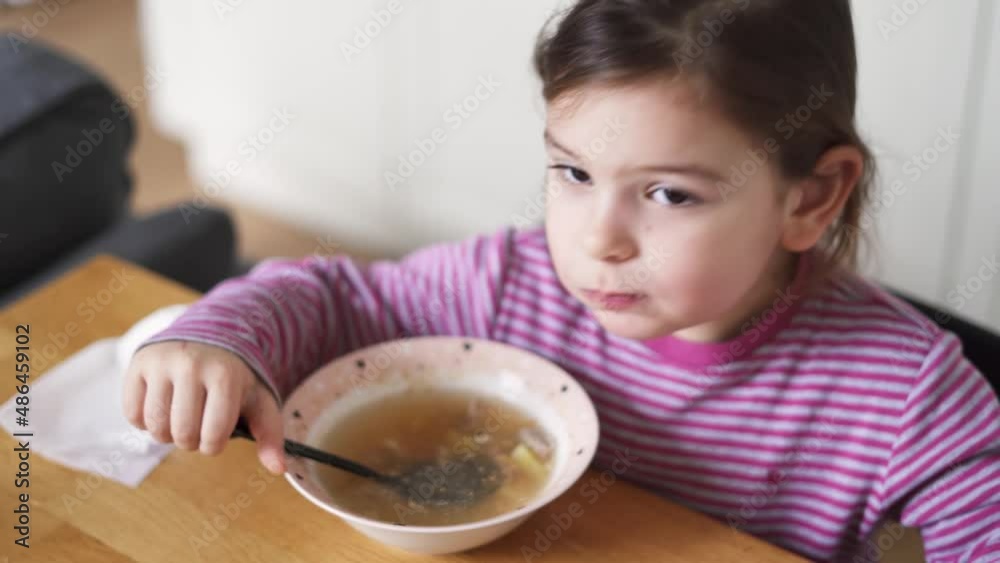 Close up of preschool girl portrait with eating soup at home. picky eater Close up of preschool girl portrait with eating soup at home. picky eater