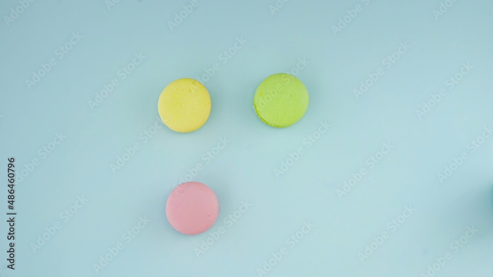 Top view of colorful french macarons on pastel blue background Top view of colorful french macarons on pastel blue background
