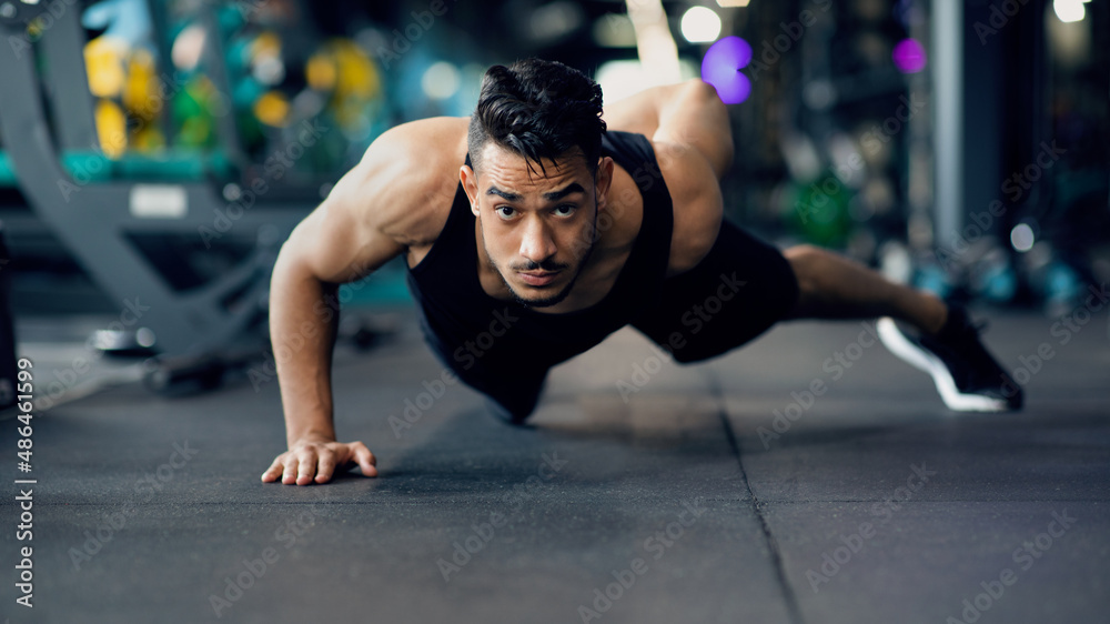 Fototapeta premium Motivated Young Arab Sportsman Making Push Up Exercise On One Hand