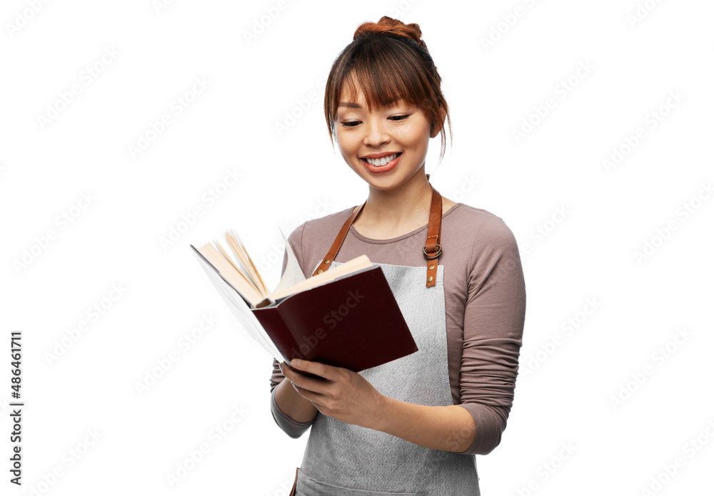 cooking, culinary and people concept - happy smiling woman in apron reading cook book over white background cooking, culinary and people concept - happy smiling woman in apron reading cook book over white background