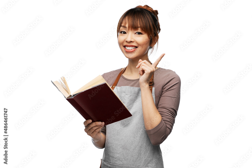 cooking, culinary and people concept - happy smiling woman in apron with open cook book over white background cooking, culinary and people concept - happy smiling woman in apron with open cook book over white background