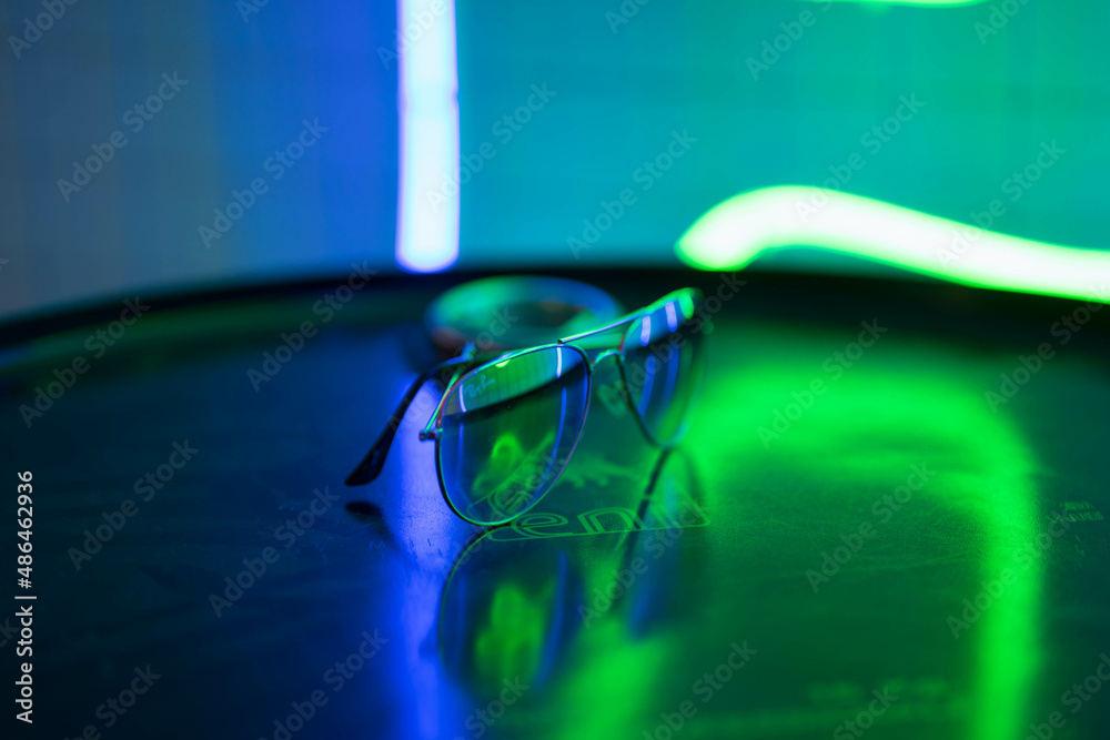 sunglasses lie on a round surface and sparkle in neon lights sunglasses lie on a round surface and sparkle in neon lights