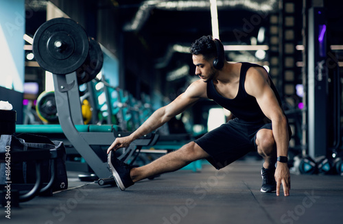 Handsome Young Middle Eastern Male Athlete Warming Up Before Training At Gym