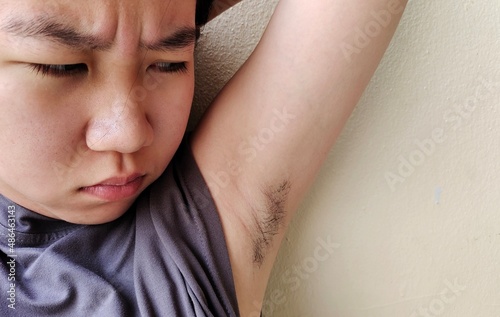 portrait of a teenage showing the armpit hair, facial expressions and worry, concept health care. photo
