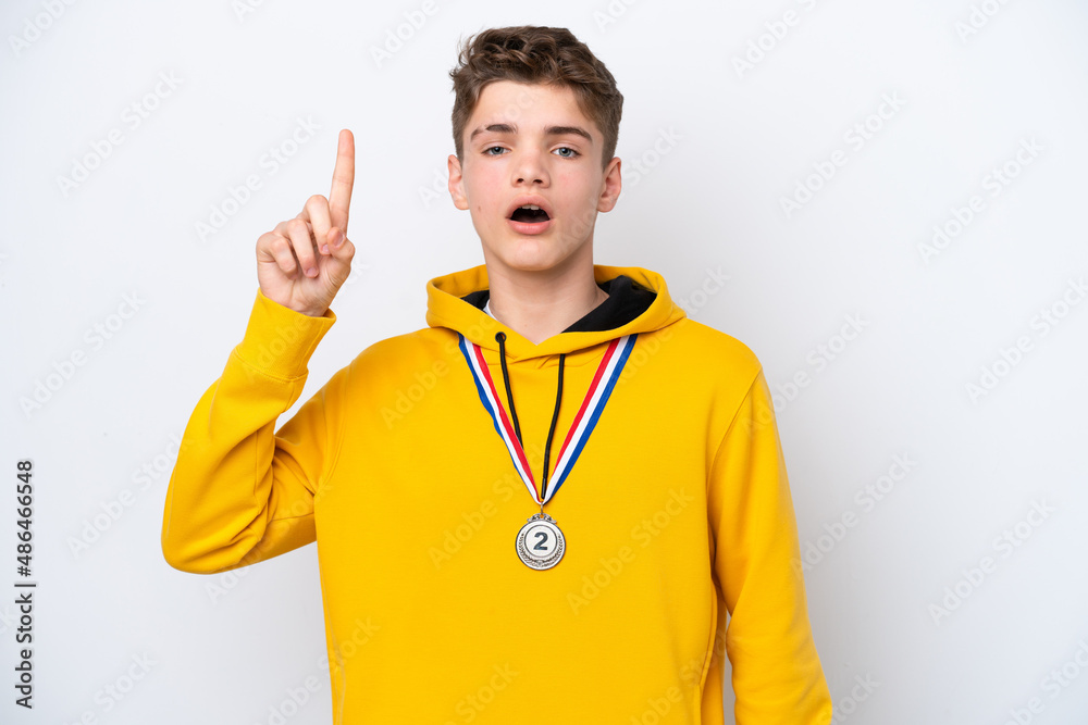 Teenager Russian man with medals isolated on white background thinking an idea pointing the finger up Teenager Russian man with medals isolated on white background thinking an idea pointing the finger up