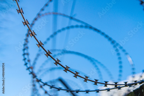 Barbed wire against the blue sky. Barbed fence close-up.