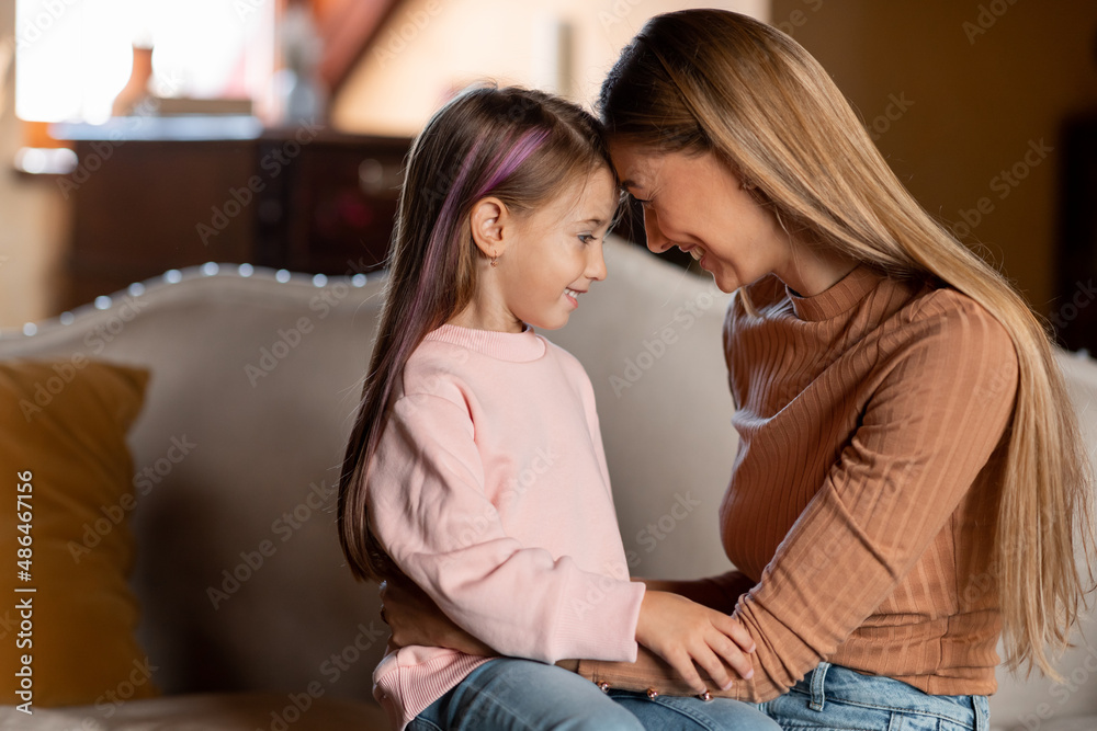 Portrait of happy woman and daughter hugging at home Portrait of happy woman and daughter hugging at home