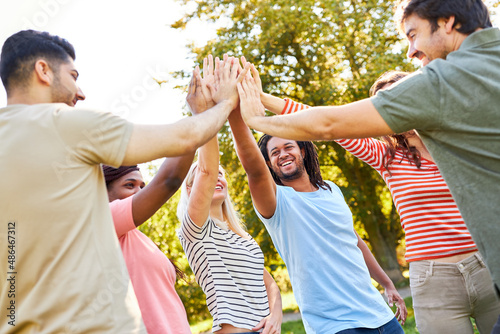 Multicultural group of young people high five photo