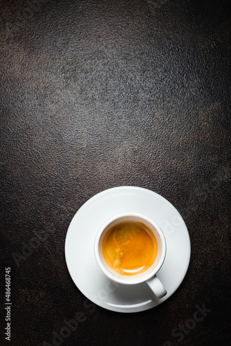 фотографія A cup of espresso coffee on a dark table, top view