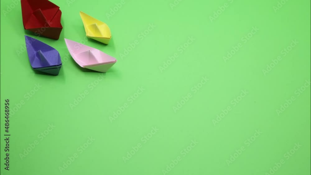 origami paper boat isolated on green background