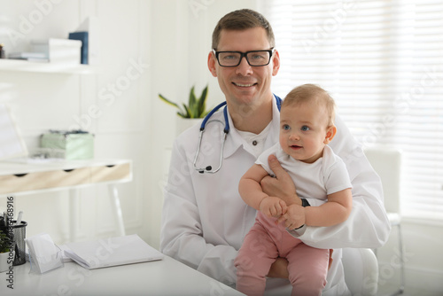 Pediatrician with cute little baby in clinic