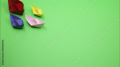 origami paper boat isolated on green background