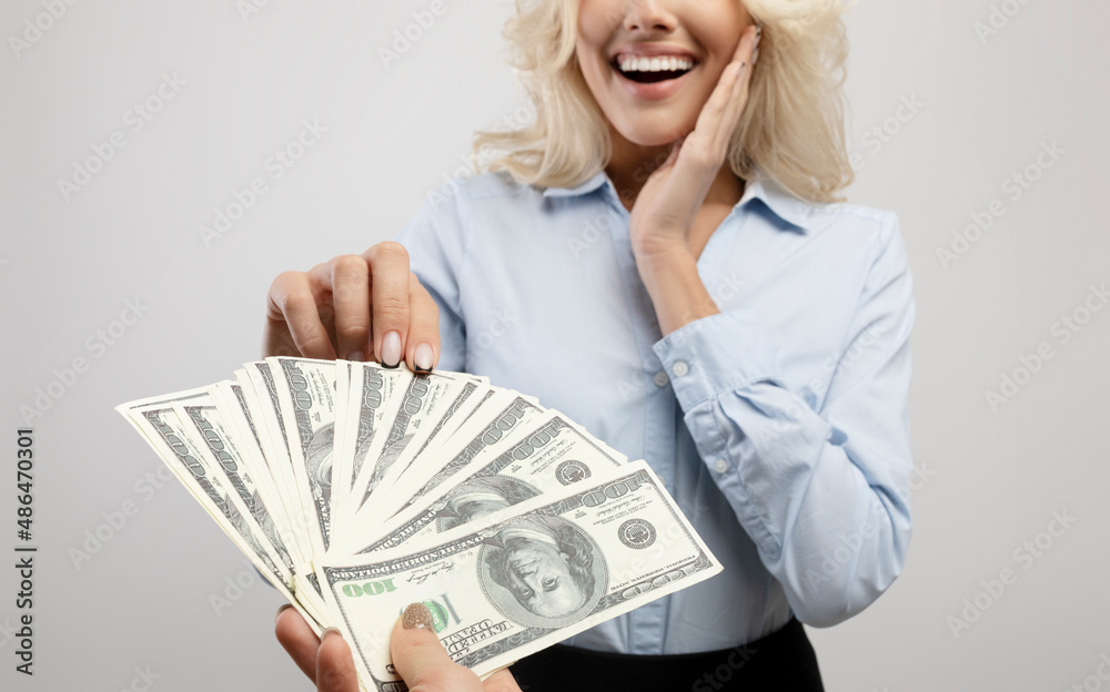 Corruption concept. Female hand giving money to surprised businesswoman on light grey studio background, closeup Corruption concept. Female hand giving money to surprised businesswoman on light grey studio background, closeup