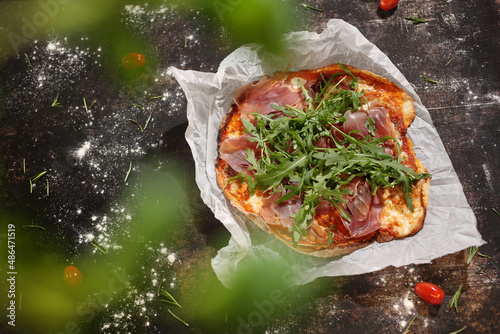 Pizza with Parma ham and arugula. Appetizing dish on a plate, culinary photography. Food background.
