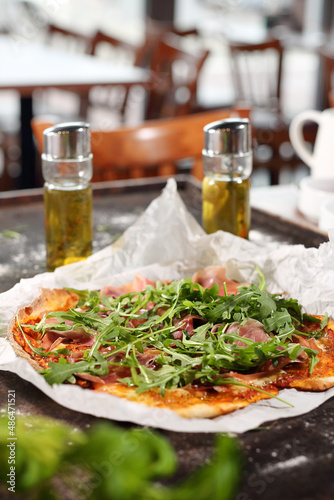 Pizza with Parma ham and arugula. Appetizing dish on a plate  culinary photography. Food background.